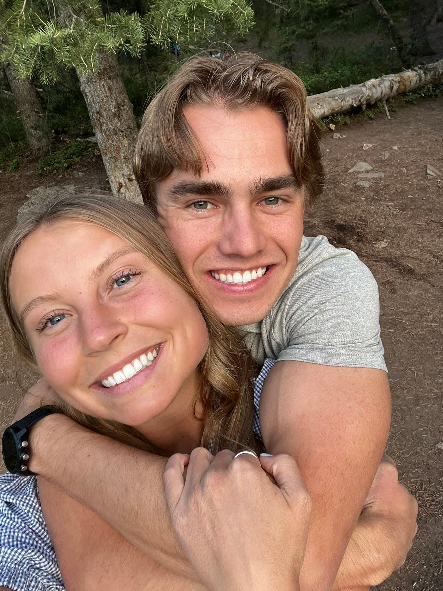 Carson and Courtney hugging outdoors on a hike